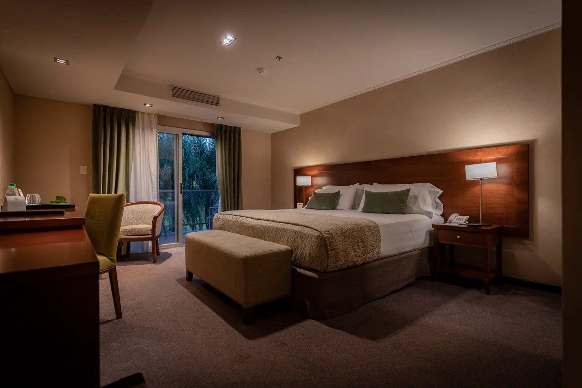 Quarto do Falls Iguazú com cama king, iluminação quente e sacada para a mata