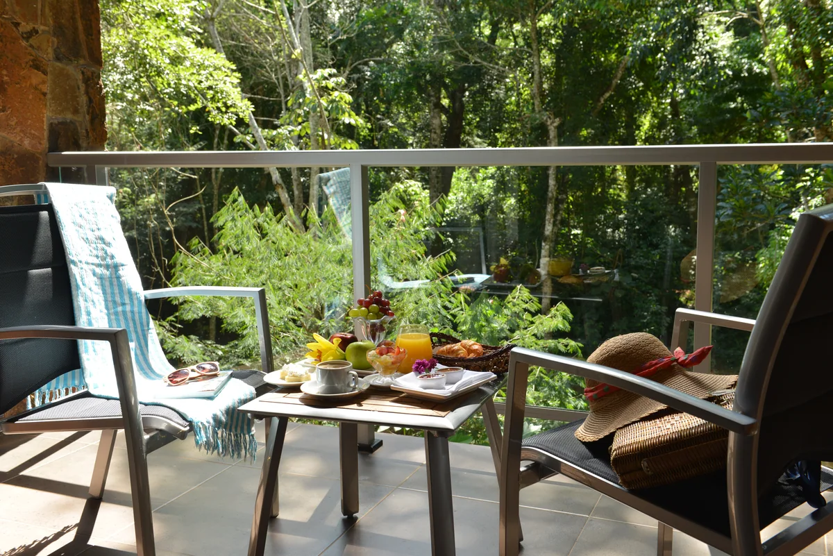 Café da manhã servido na varanda de um quarto Master, com vista para a mata