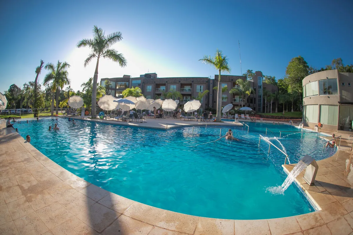 Piscina do Falls Iguazú em plano aberto, cercada pelo complexo e pela mata